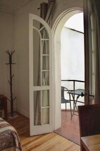 圣地亚哥Hotel De Blasis的一间设有通往阳台的门的房间