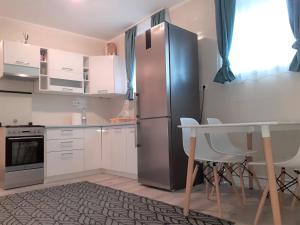 凯斯特海伊Nelli Apartman的厨房配有不锈钢冰箱和桌子
