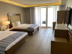 Madame CartyAll Inclusive- Divi Carina Bay Beach Resort & Casino Adult Only的酒店客房设有两张床和电视。