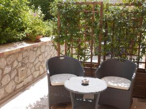 阿纳卡普里其赛雷别墅酒店的庭院里设有两把椅子和一张桌子