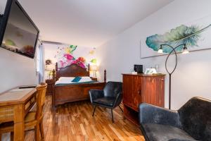 魁北克市家乐德布瓦旅馆的一间卧室配有一张床、一张桌子和一把椅子
