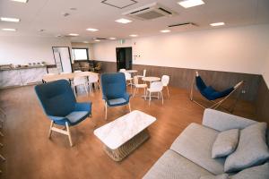 舞鹤市GATEWAY MAIZURU的一间设有椅子、一张沙发和一张桌子的等候室