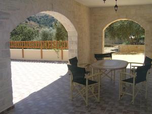 KaloniktisStratos Villas的一个带桌椅的庭院和一个阳台