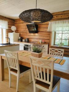 HellamaaHellamaa Retrovisiit Alma & Vilma的厨房配有木桌和白色椅子