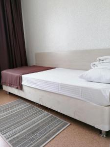 巴尔瑙尔Hotel Kolos的一张带白色床单和红色毯子的床