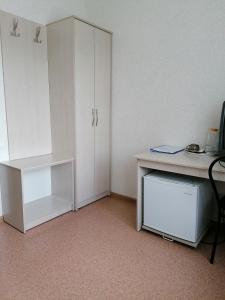 巴尔瑙尔Hotel Kolos的一间设有白色书桌和白色橱柜的客房