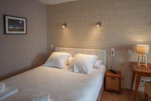 图阿尔lhotel的一间卧室配有带白色床单和枕头的床。
