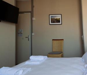图阿尔lhotel的酒店客房设有一张床,墙上挂着一张照片