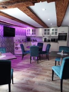 乌埃克尔明德AnaCapri Gästehaus Girona的一间拥有紫色墙壁和桌椅的用餐室