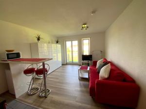 辛根Apartment- Singen Überlinger Straße的客厅配有红色的沙发和桌子