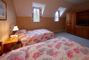 佐世保豪斯登堡森林别墅的一间卧室配有两张床、一个梳妆台和一张桌子