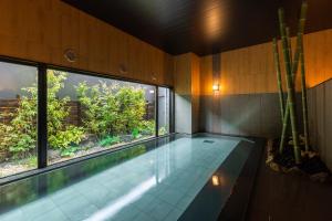 米子市Hotel Route-Inn Yonago的一个带大窗户的房间内的游泳池