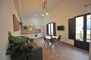 赫雷斯-德拉弗龙特拉Palacete Centro estilo Luxe的一间带桌椅的客厅和一间厨房