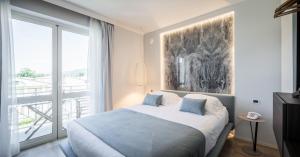 马里纳迪马萨卢纳酒店的一间卧室设有一张床和一个大窗户