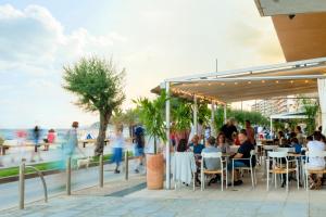 圣安东尼奥·德·卡隆奥尔加旅馆的一群人坐在海滩附近的餐馆里