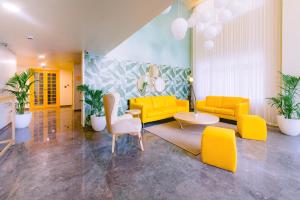 班加罗尔Bloom Hotel - Indiranagar的客厅配有黄色家具和植物