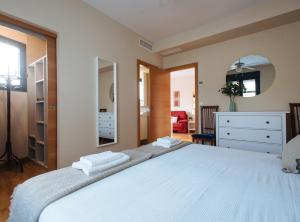 塞维利亚Torneo Suite Apartment的卧室配有一张带镜子的白色大床