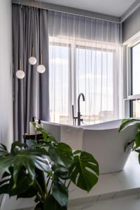 波兹南Choya Apartments的一间带大浴缸和植物的浴室