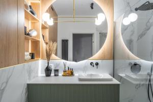 波兹南Choya Apartments的一间带水槽和镜子的浴室