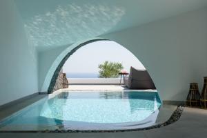 费拉Este Luxury Suites的一座带拱门的房子中的游泳池