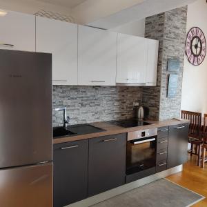 布雷拉Apartmani Mira Brela的厨房配有不锈钢用具和白色橱柜