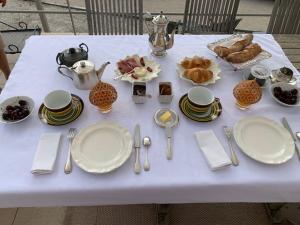 维逊拉洛梅尼L 'Havéli的一张带盘子和餐具的白色桌子