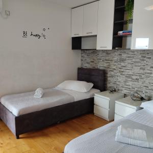 布雷拉Apartmani Mira Brela的一间卧室设有两张床和砖墙