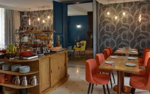 贝叶Château Saint Gilles的餐厅设有木桌和红色椅子