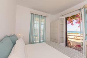 AgiassosStudios Strouvalis的一间卧室设有一张床,并有通往海滩的门