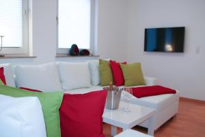 维岑豪森Premium Ferienwohnung Sonnenaufgang的客厅配有白色沙发、红色和绿色枕头