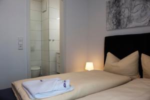 康斯坦茨维森塔勒尔伽尼酒店的一间卧室配有一张带白色毛巾的床