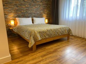 UngureniPodina Resort Hotel & Spa的一间卧室设有一张床和砖墙