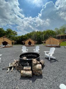 沃特金斯格伦Naturluxe & Stars的一组椅子、一个烧烤架和一些帐篷