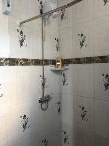 楚伊Hostal Lo de Mili的墙上设有黑色花卉淋浴的浴室