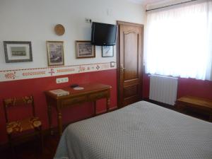 圣塞瓦斯蒂安乐库埃德酒店的卧室配有一张床,墙上配有电视。