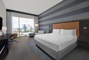 休斯顿Holiday Inn Express - Houston - Galleria Area, an IHG Hotel的酒店客房设有一张大床和一张沙发。