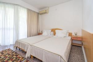 维纳斯拉卢卡酒店 的酒店客房设有两张床和窗户。