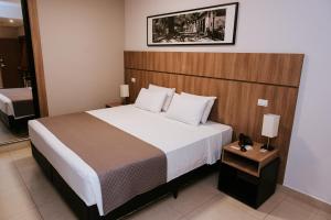 皮拉西卡巴欧西塔诺阿帕特酒店的一间卧室配有一张大床和木制床头板