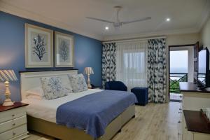 UmzumbePumula Beach Hotel的一间卧室配有一张蓝色墙壁的床