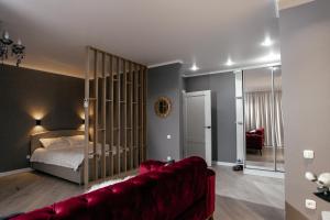 乌拉尔斯克LUX 6 МКР дизайнерская комфортная студия с панорамными дверьми и большой лоджией的客厅配有床和红色沙发