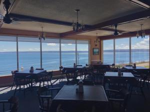 迪格比Admiral Digby Inn Restaurant and Cottages的一间带桌椅的海景餐厅