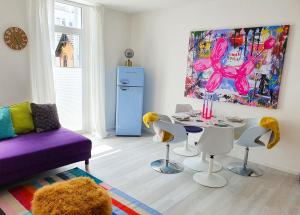 森夫滕贝格PB Ferienwohnungen - FeWo 6 - Stilvoll eingerichtetes Apartment im Herzen Senftenbergs的客厅配有桌椅和绘画作品