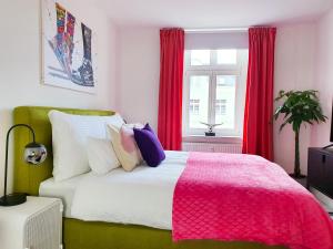 森夫滕贝格PB Ferienwohnungen - FeWo 6 - Stilvoll eingerichtetes Apartment im Herzen Senftenbergs的一间卧室配有一张带粉色毯子的大床
