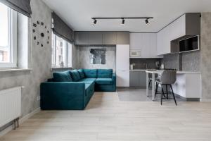 利沃夫Magic Apart 10的一间带蓝色沙发的客厅和一间厨房
