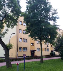 奥斯威辛Lovely place-apartament Oświęcim的前面有两棵树的建筑