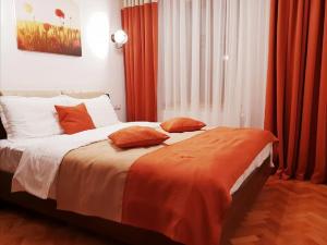 锡比乌Studio Piata Mare apartments的一间卧室配有带橙色窗帘的大床