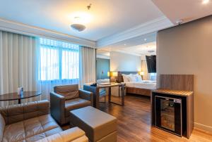 弗洛里亚诺波利斯蓝树高级弗洛里亚诺波利斯旅馆的酒店客房设有床和客厅。