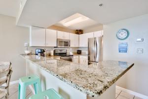 德斯坦Pelican Beach Resort Condos的厨房配有白色橱柜和花岗岩台面