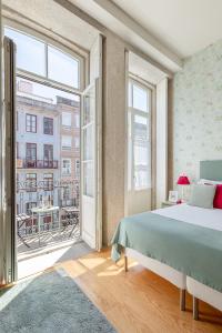 波尔图Inside Porto Apartments - Mouzinho的一间卧室设有一张床和一个大窗户