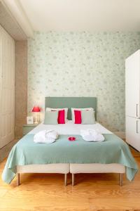 波尔图Inside Porto Apartments - Mouzinho的一间卧室配有一张床,上面有两条毛巾